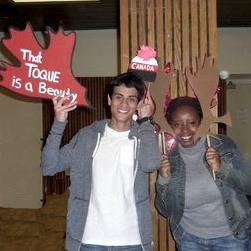 two students with cardboard cut outs of moose antlers and a toque 