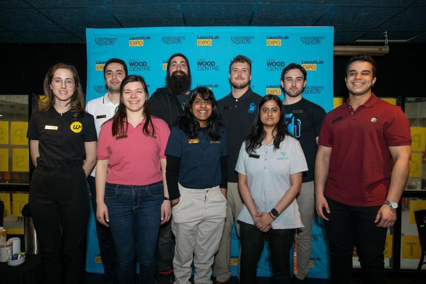 8 students standing in 2 rows posing for a picture