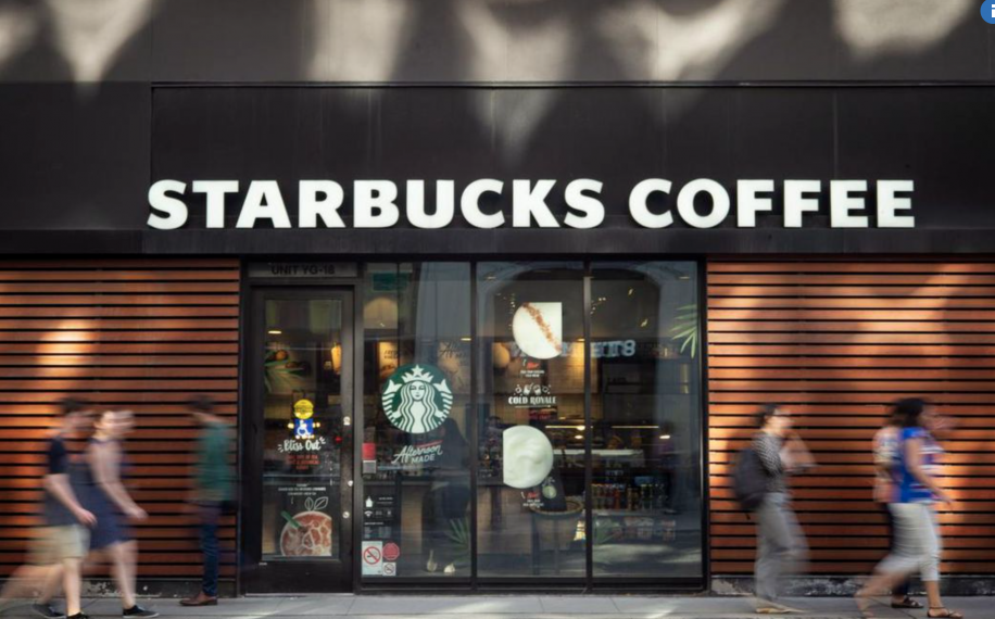 People walking in front of Starbucks Coffee.