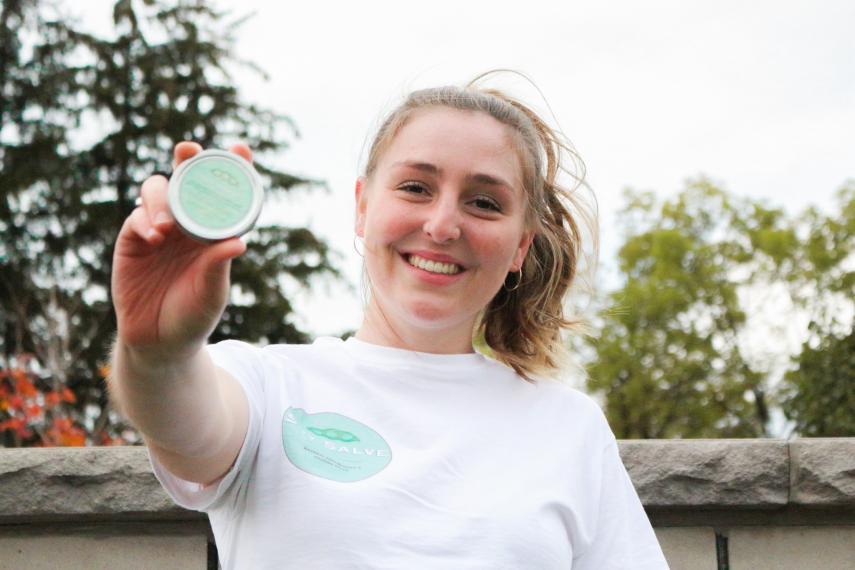 Olivia from Soy Salve holding up their product.