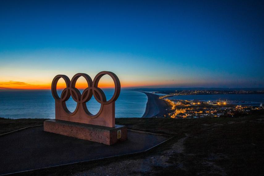 Olympic rings with a city at night in the background