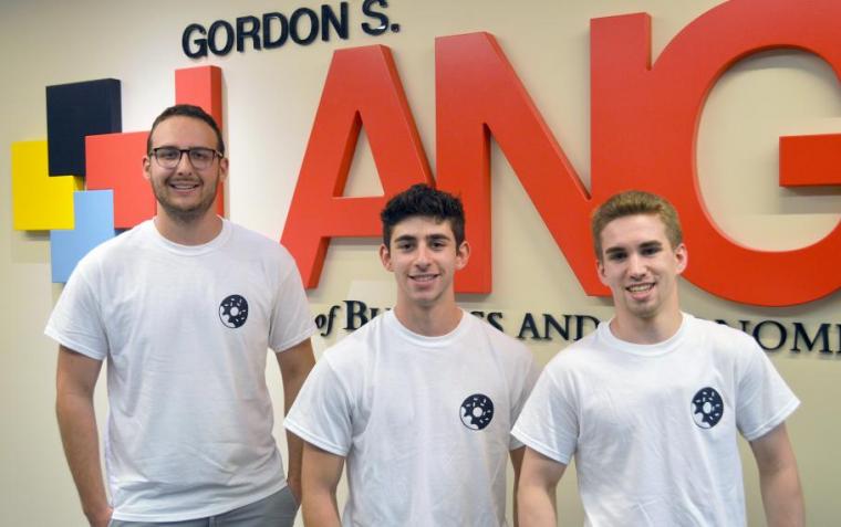 Lang business students in front of Lang sign