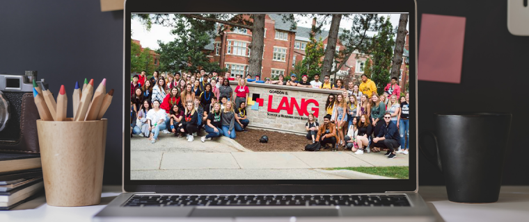 Photo of a laptop with an image of Lang Students on the screen