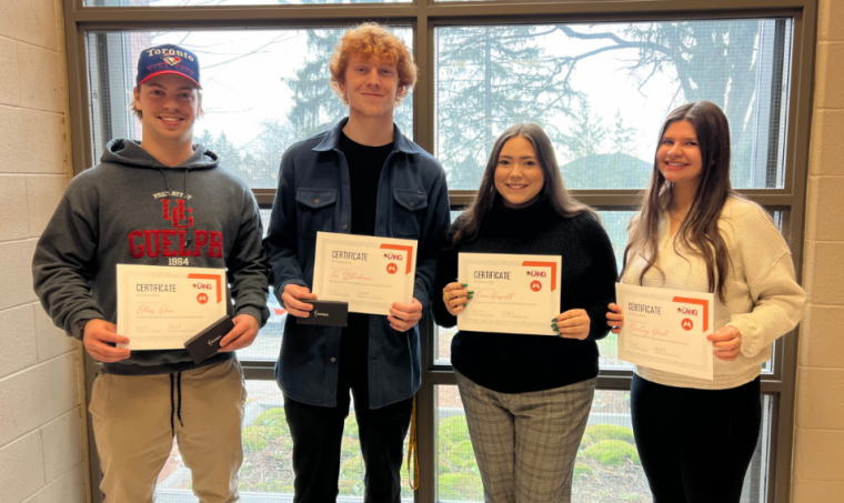 Four commerce students holding their winning certificate