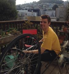 Cole Crawford on balcony working on his bike