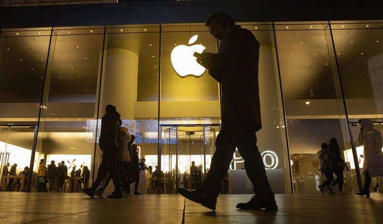 people walking past Apple store