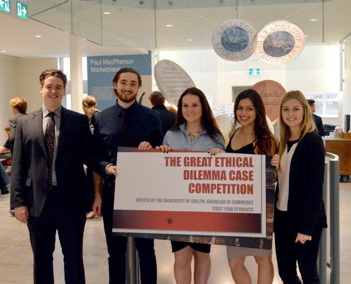 First-year students pose with the Great Ethical Dilemma Case Competition sign