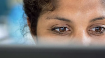 Someone looking at a screen with the back of the screen showing across the bottom of the photo.