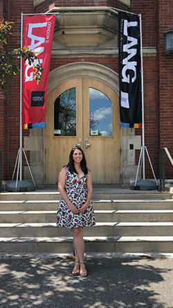 Photo of Brittany in front of Macdonald Hall on campus