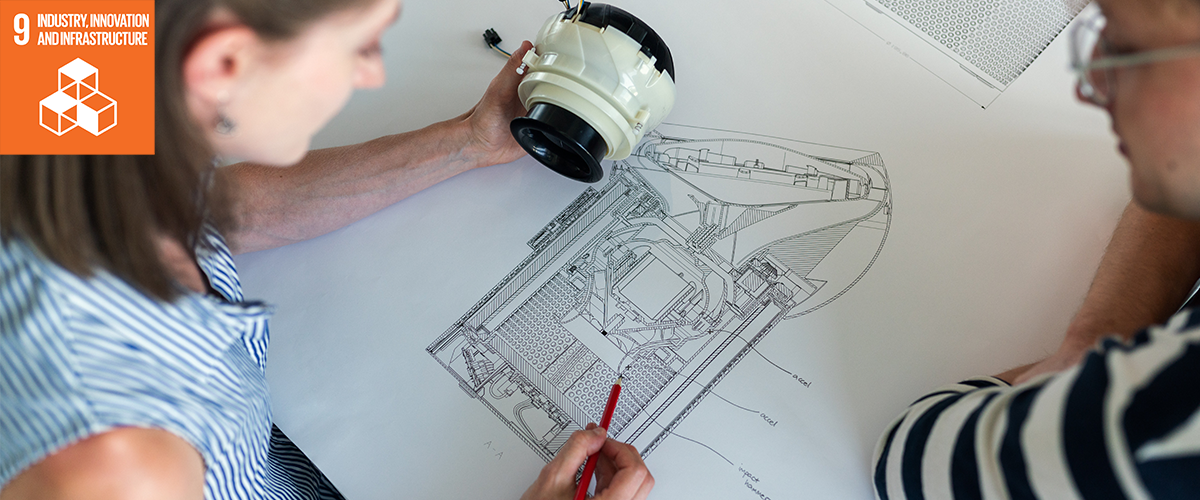 Photo of engineers working on a design drawing