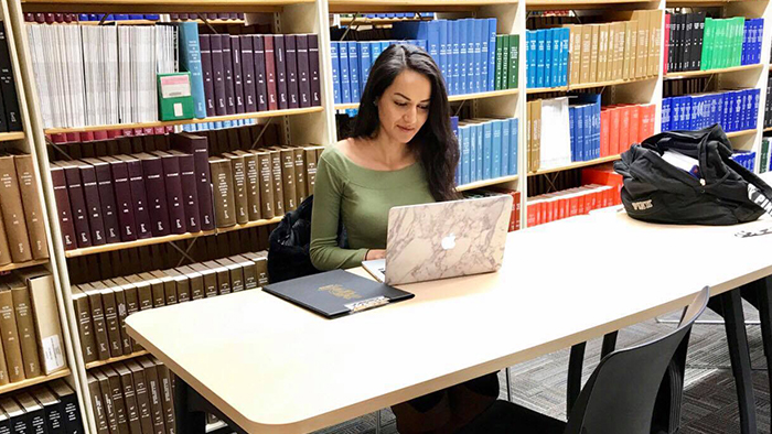 Albina studies in the library at U of G