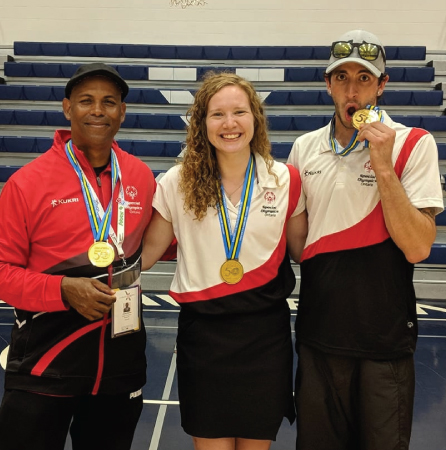 Camille Gardiner (centre) and coaches of the Special Olympics basketball team, winning gold at the national competition.