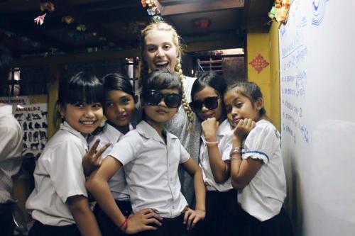 Leah posing with a group of five of her students in cambodia