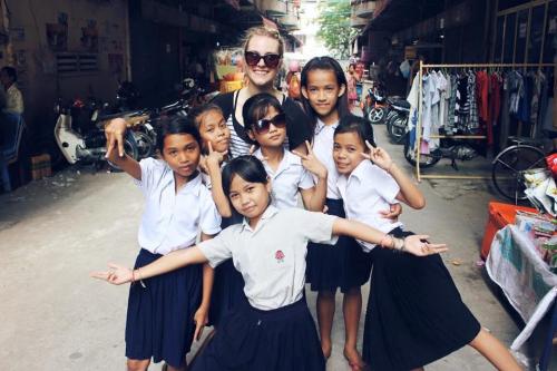 Photo of Leah posing with a group of six students in Cambodia