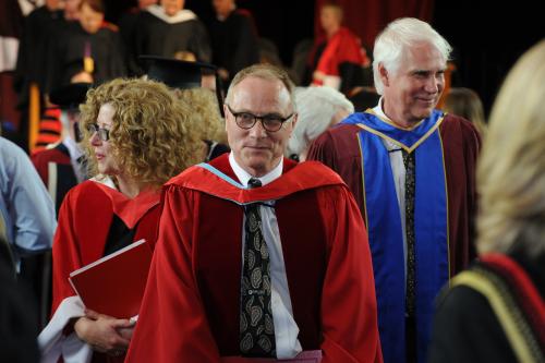 Photo of David Card leaving the convocation ceremony in Memorial Hall