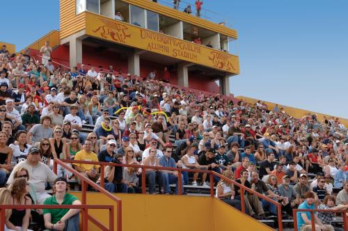 People sitting in alumni stadium watching the homecoming football game