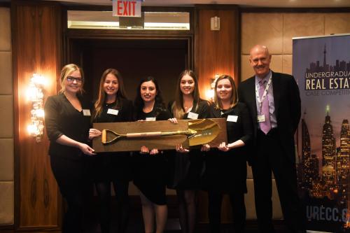 Winning team holding golden shovel 