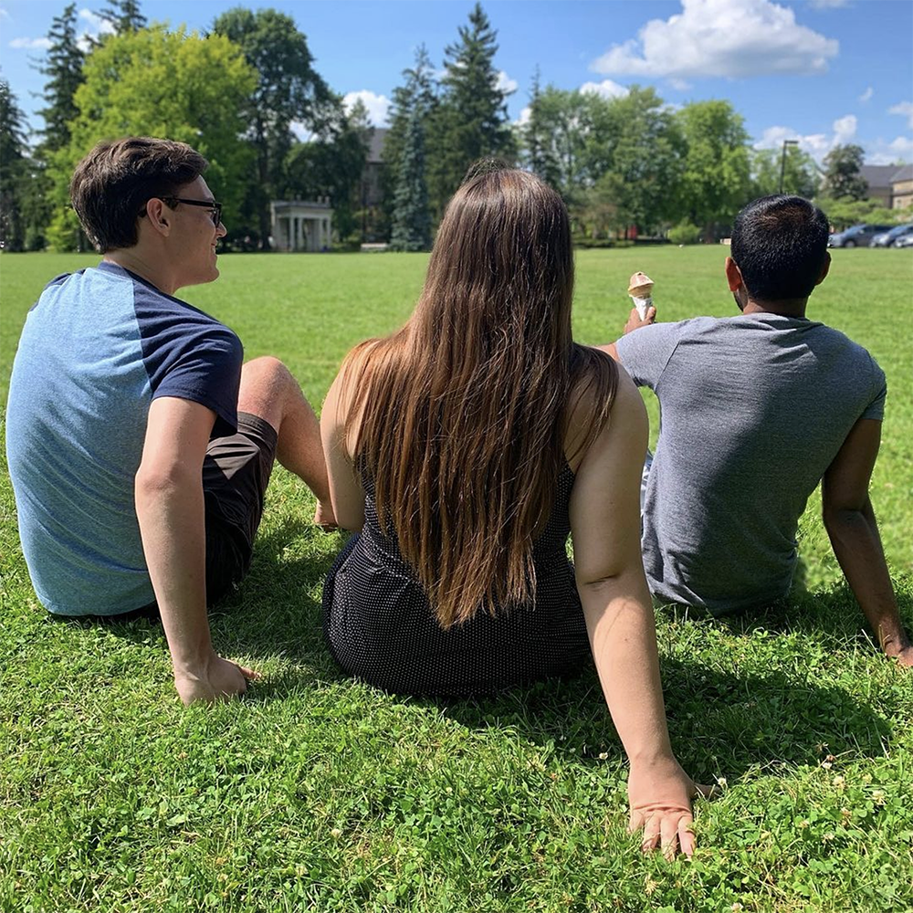 Students sitting on Johnston Green with The Portico in the distance