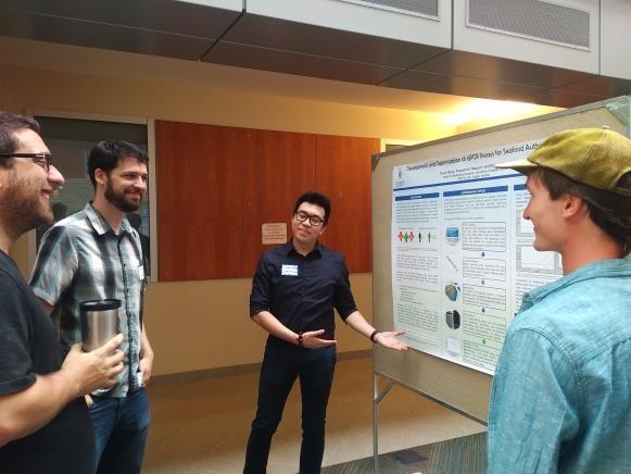 A student presenting his poster to peers