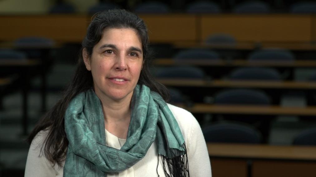 Katerina Jordan in empty lecture hall, wearing mint green scarf