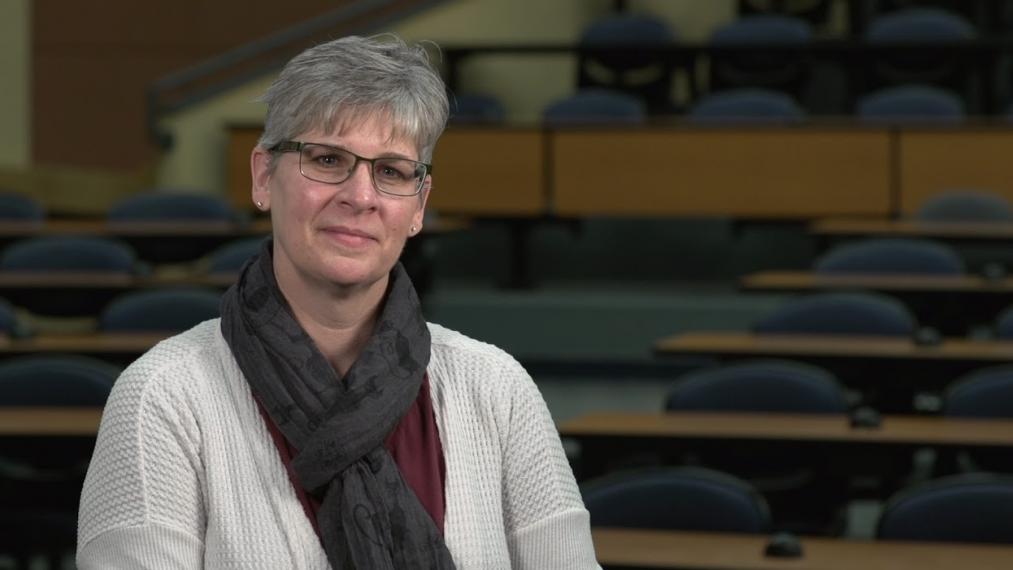 Head shot photo of Prof. Lisa Duizer sitting in empty lecture hall