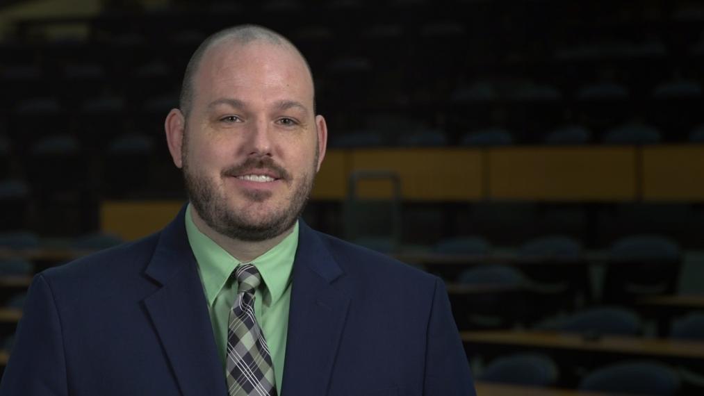 Head shot photo of Mike Rogers in a dark lecture rooom