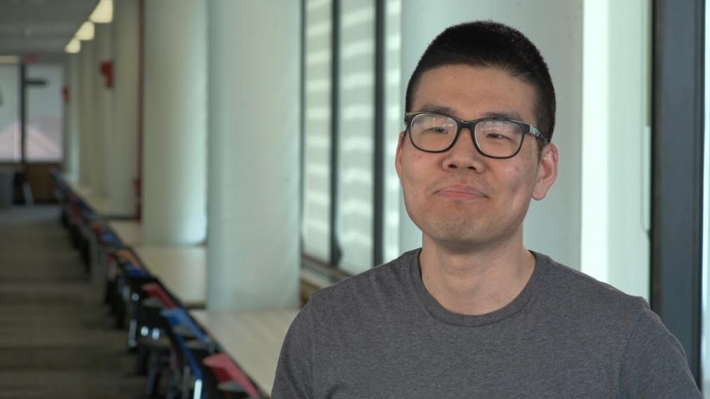 Head shot of Peter Park in front of wall of windows