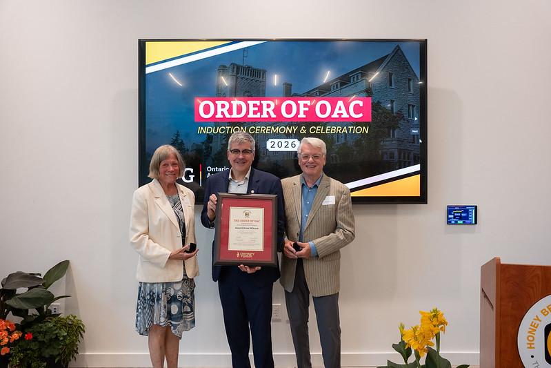 Anne and Brian Wilcock receiving an award from John Cranfeild