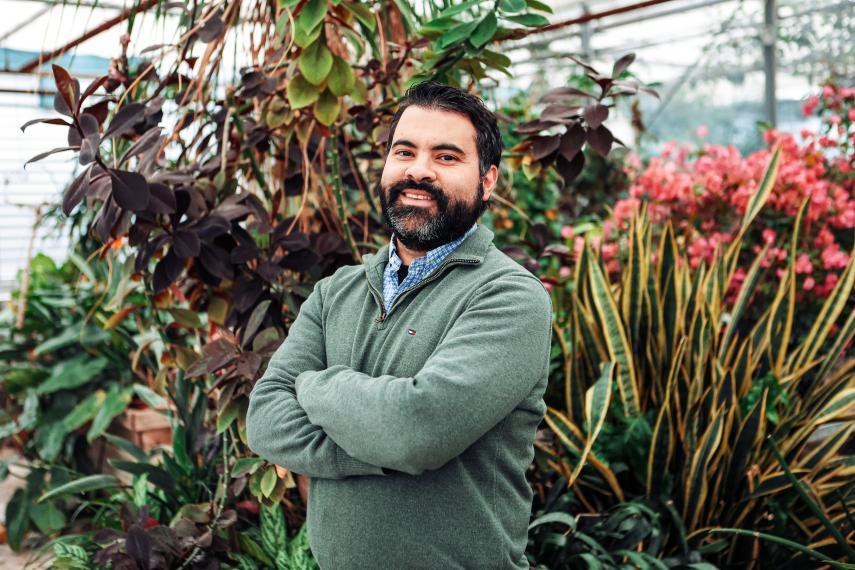 Dr. Adrian Correndo smiling for the camera in the Bovey Greenhouse