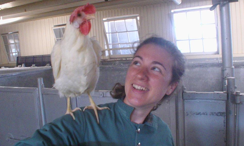 Claire smiling with a chicken on her shoulder