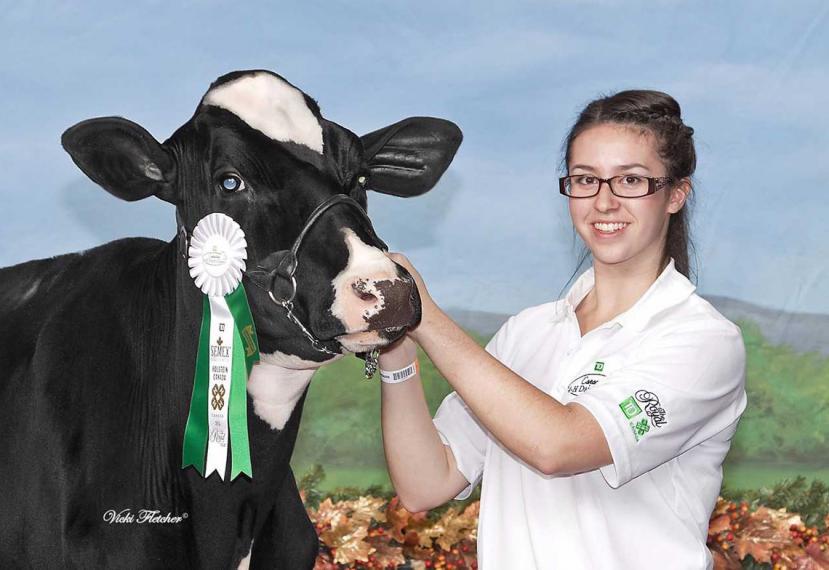 Emma poses while holding her prize winning cow