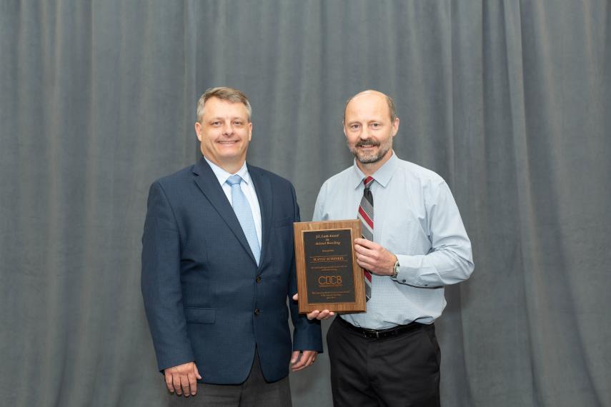Flavio holds his award next to the presenter.