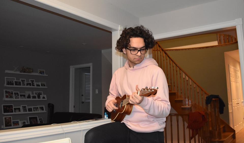 Head shot of Stephen Dawoud, playing the ukulele.