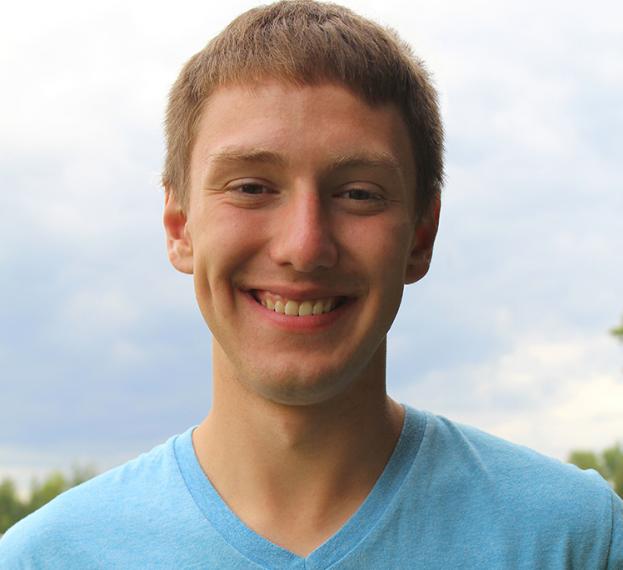 Caleb Niemeyer stands in a field in a blue shirt.