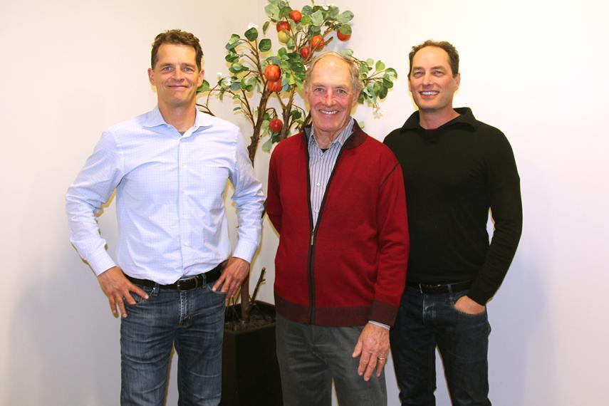 Dean, Tom and Scott Chudleigh stand together in front of faux apple tree