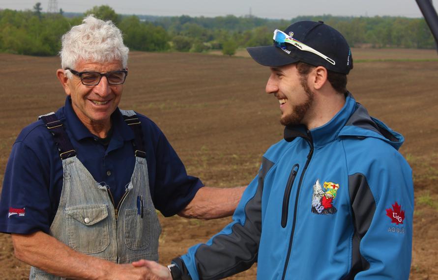 Dylan shakes hands with a farmer.
