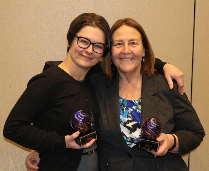 Kate Shoveller and Gail Kuhlman pose together with awards