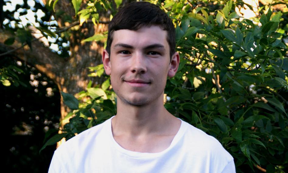 Simon Bissonnette stands outside under a tree.