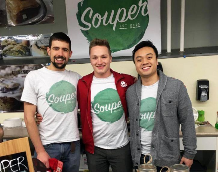 Brandon, Dylan and Allan stand together wearing matching "Souper" shirts and "Souper" sign in background