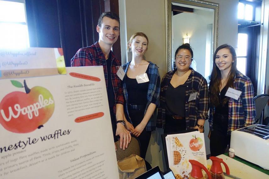 Four students stand behind their project.