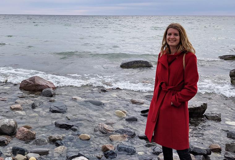 Danielle standing on a shore with a body of water in the background