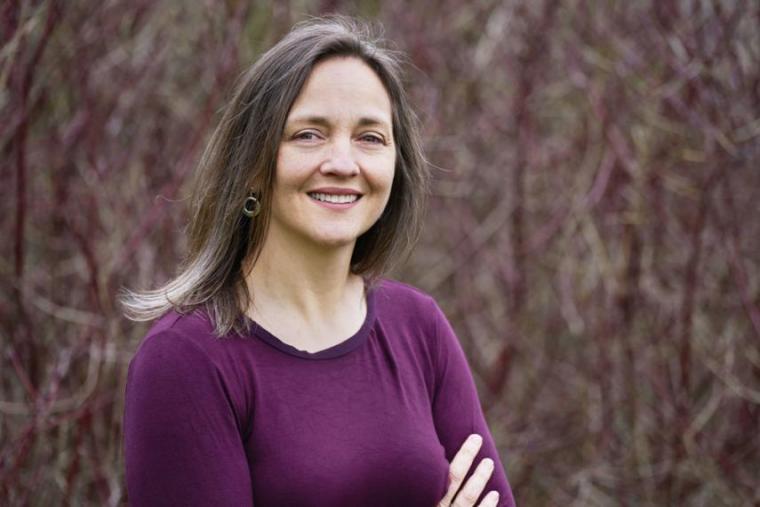 Justine wearing purple shirt with brown trees in the background