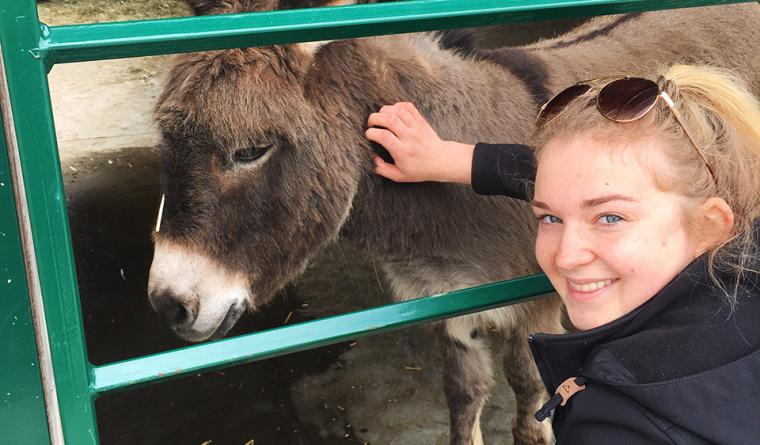 Natalia poses with a donkey.