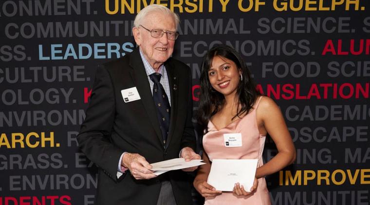 Past Dean, Clay Switzer, presents Sneha with her scholarship.