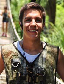 Headshot of Daniel Johnson wearing green vest with an ear piece in.