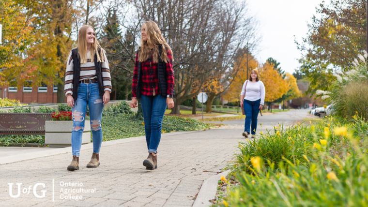 Two women walk together smiling on Guelph's Ridgetown campus.