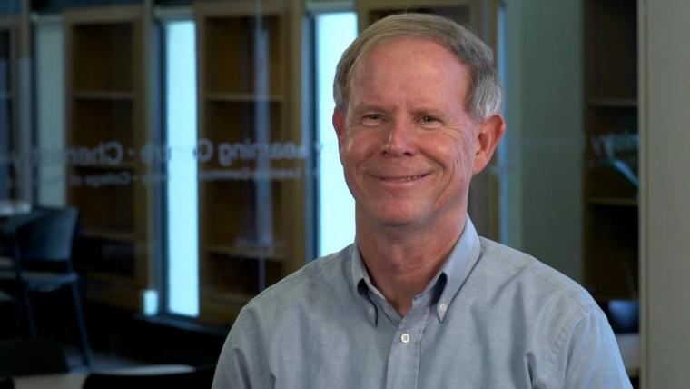 Al Sullivan smiling in front of a glass wall.