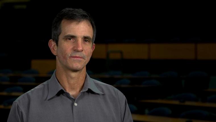 Alejandro Marangoni head shot sitting in dark lecture hall