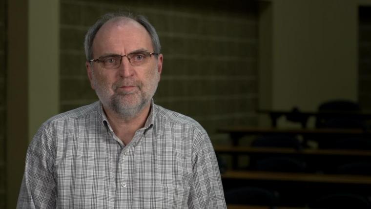 Head shot of Jim Squires wearing a grey check shirt