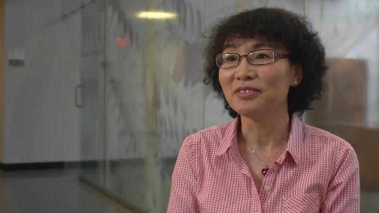 Julang in pink shirt sitting in front of transparent glass wall